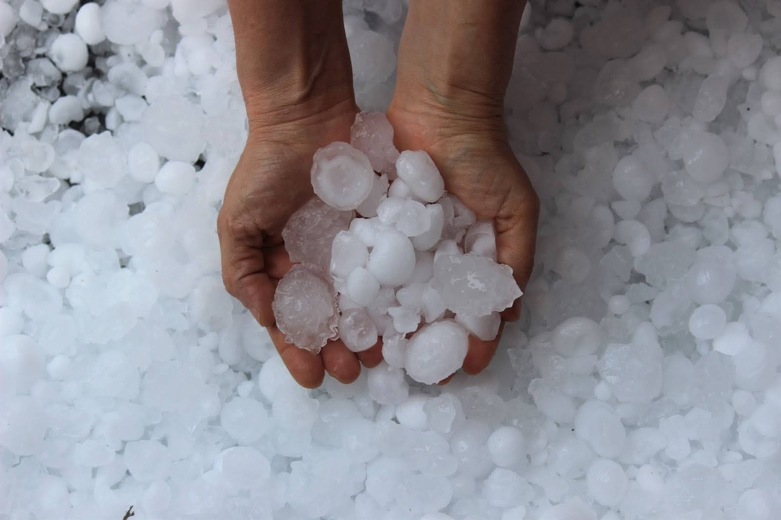 a man holding large balls of hail in his hands